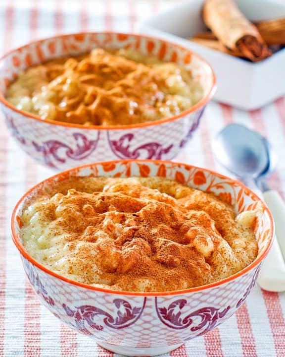two bowls of homemade Kozy Shack rice pudding and cinnamon sticks