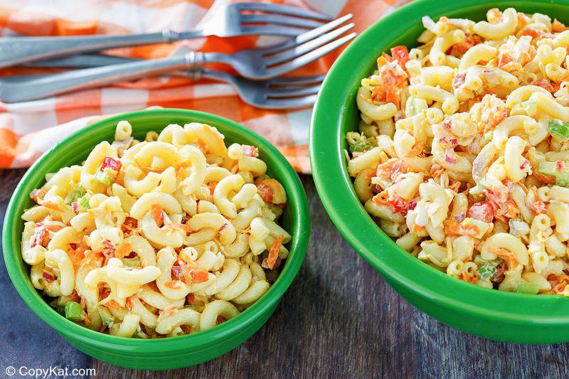 homemade macaroni salad in two bowls and forks on a napkin