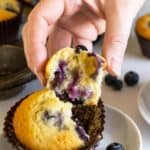 hand holding half of a blueberry muffin