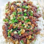 Mongolian beef with mushrooms over rice on a platter