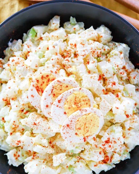 potato salad topped with sliced egg and paprika