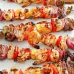 six shish kabobs with chicken, steak, shrimp, and vegetables