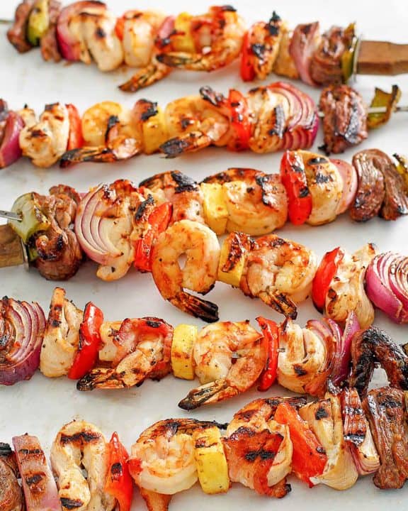 six shish kabobs with chicken, steak, shrimp, and vegetables