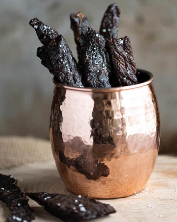 pieces of homemade teriyaki beef jerky in a cup