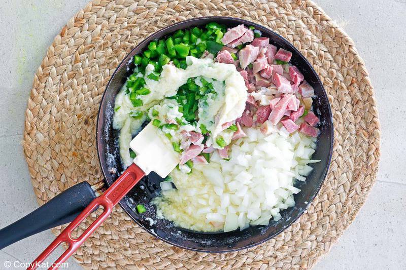 cheesy scalloped potatoes and ham casserole sauce in a skillet