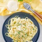 overhead view of fettuccine noodles with creamy alfredo sauce and parmesan cheese