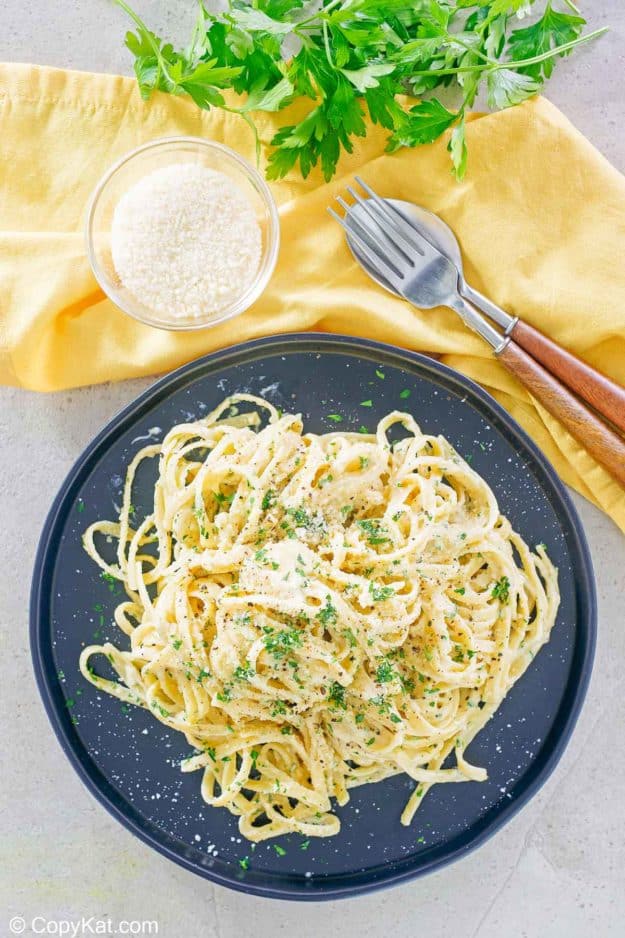 overhead view of fettuccine noodles with creamy alfredo sauce and parmesan cheese