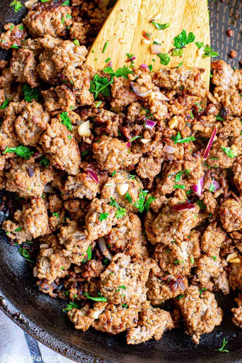 cooked ground beef, onions, and cilantro in a skillet