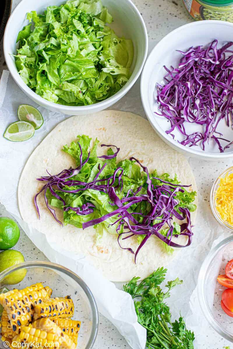 lettuce and red cabbage on a flour tortilla
