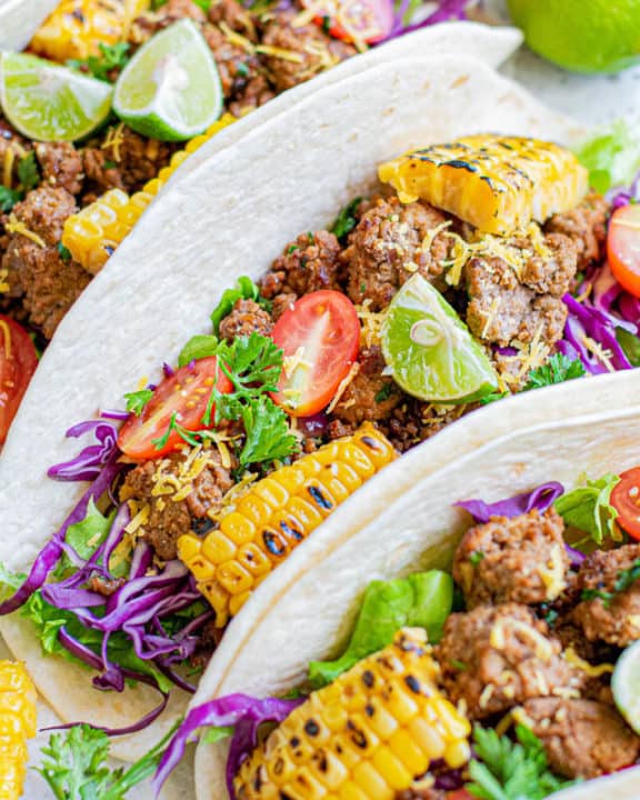 three ground beef tacos with soft flour tortillas