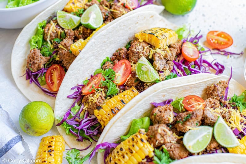 three ground beef tacos with soft flour tortillas