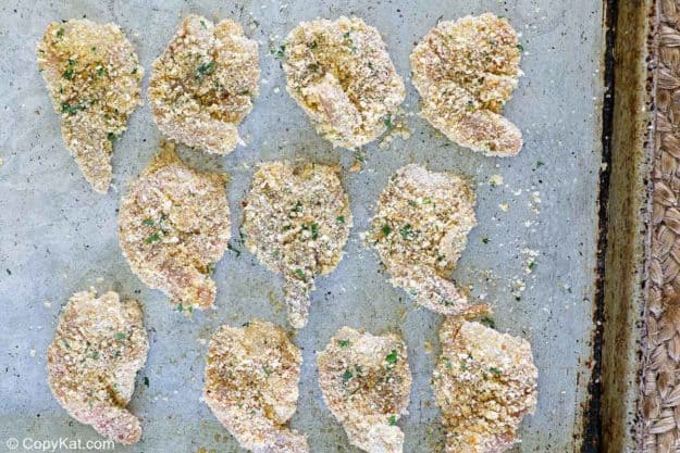 breaded raw shrimp on a baking sheet