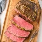 overhead view of cooked and sliced NY strip roast on a cutting board