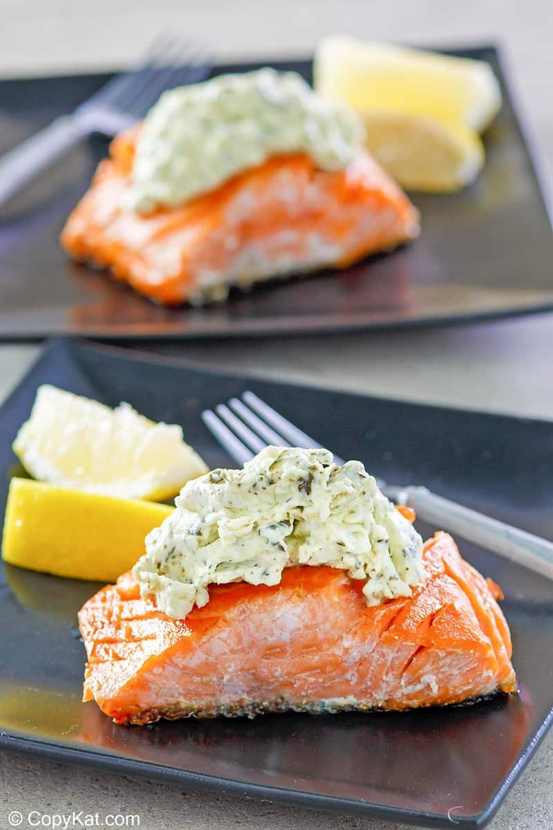 two servings of pan fried salmon with pesto cream cheese sauce