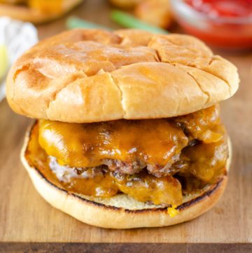 Homemade Steak and Shake garlic double cheeseburger on a wood cutting board.