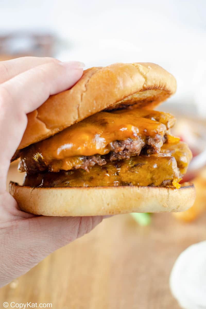 Hand holding a homemade Steak and Shake Garlic Double Steakburger.
