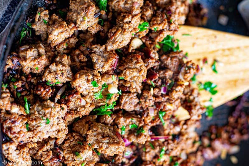 browned ground beef, onions, and tomato puree in a skillet