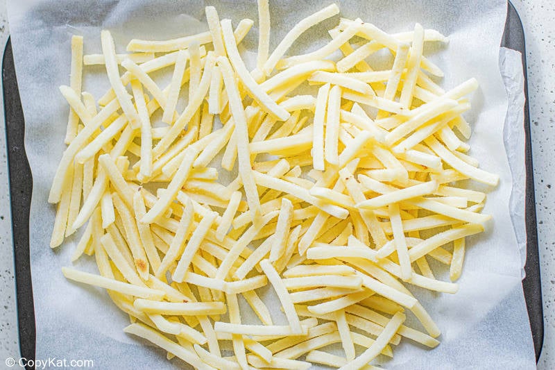 frozen French fries on a baking sheet