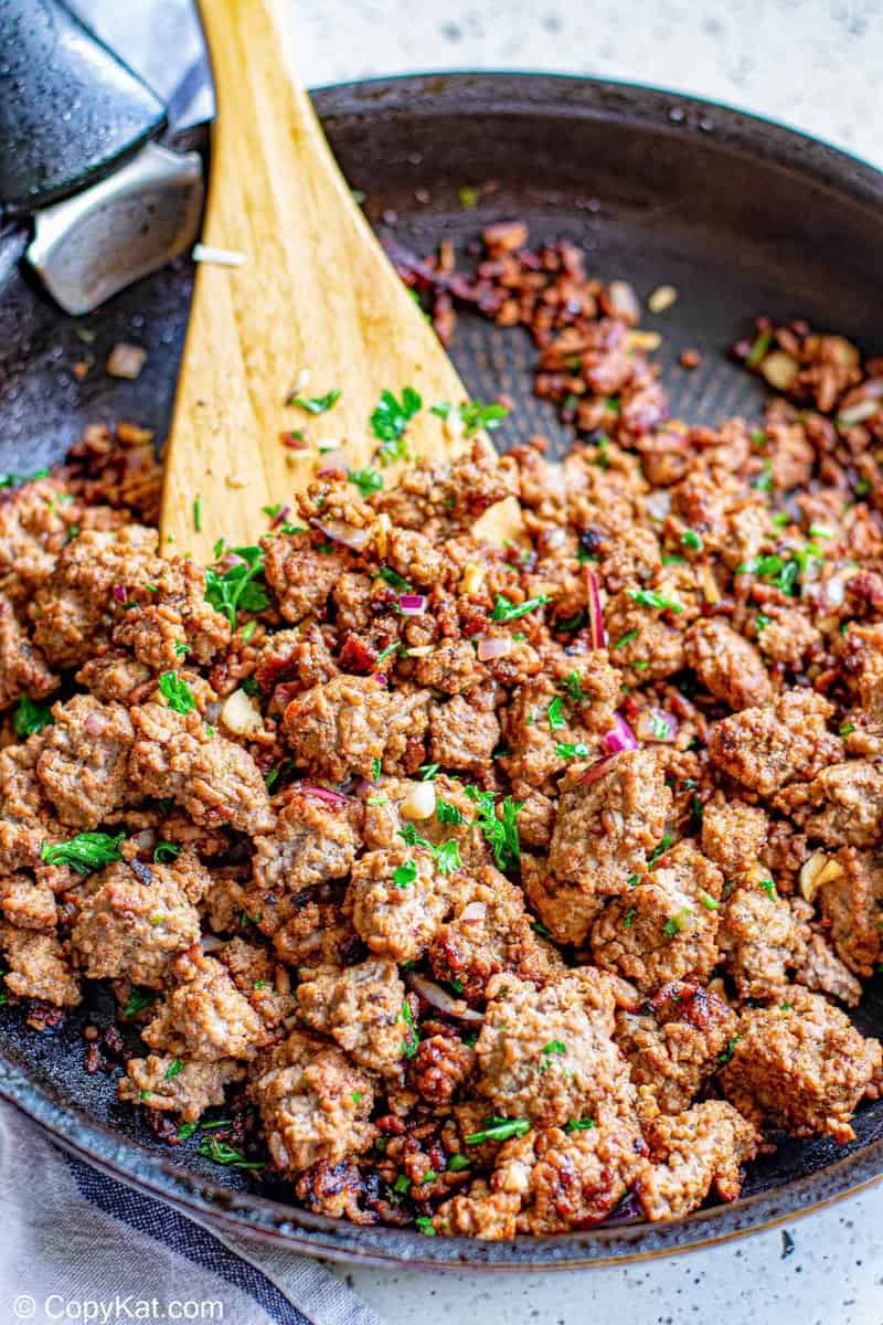 cooked taco ground beef, tomato puree, onions, and cilantro in a skillet