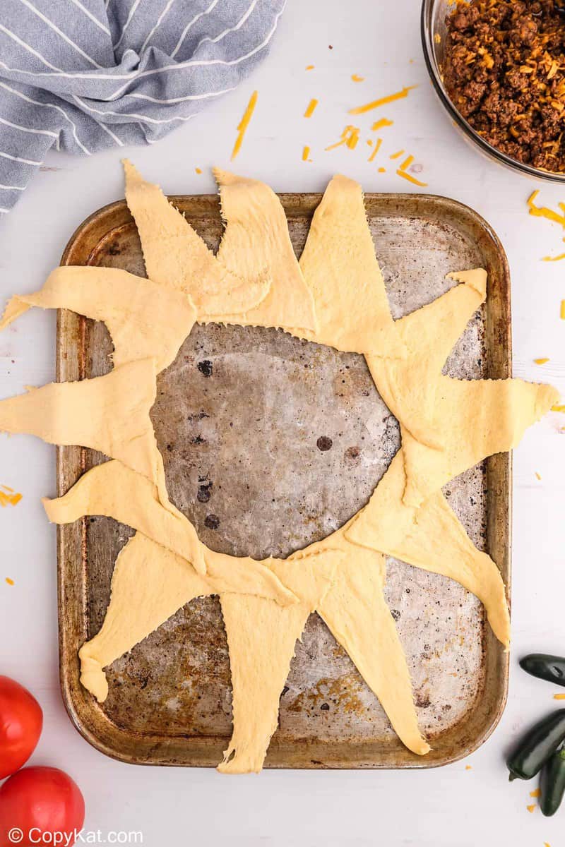 crescent roll triangles in a circle on a baking sheet