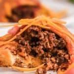 piece of a taco ring topped with cheese on a plate