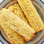 overhead view of air fried corn on the cob on a plate