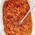overhead view of BBQ baked beans and a spoon in a serving dish