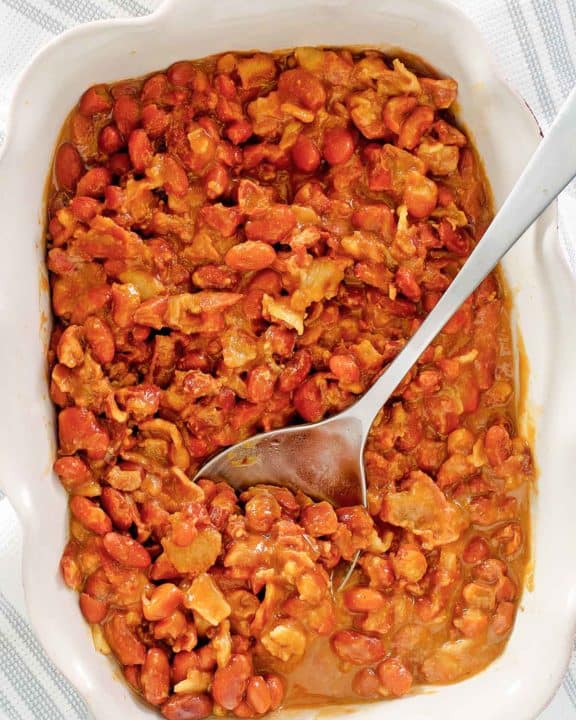 overhead view of BBQ baked beans and a spoon in a serving dish