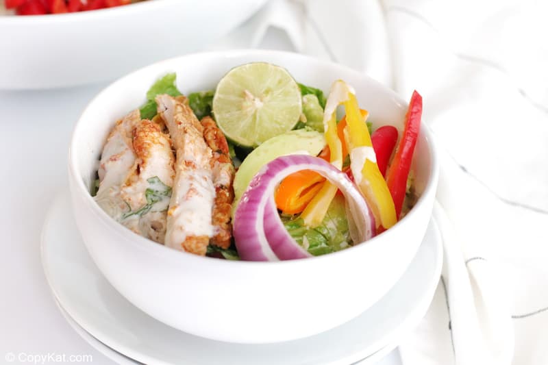 chicken fajita salad in a bowl on top of plates