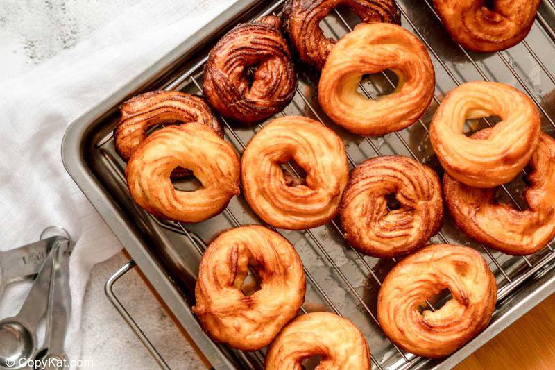 fried French cruller donuts on a wire rack