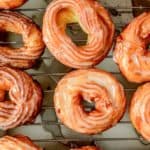a dozen French cruller donuts on a wire rack