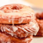 three French cruller donuts stacked on a plate