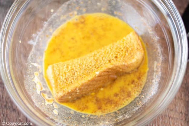 dipping a bread slice into French toast batter