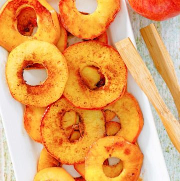overhead view of fried apples, an apple, and wood tongs