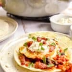 huevos rancheros with bacon and crema fresca on a plate