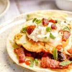 huevos rancheros topped with crema fresca and bacon