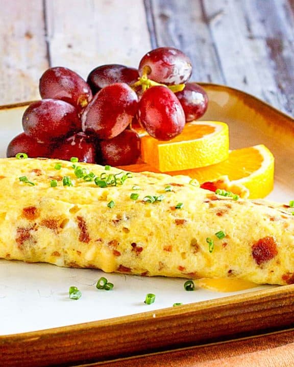 bacon and cheese omelette and fruit on a plate