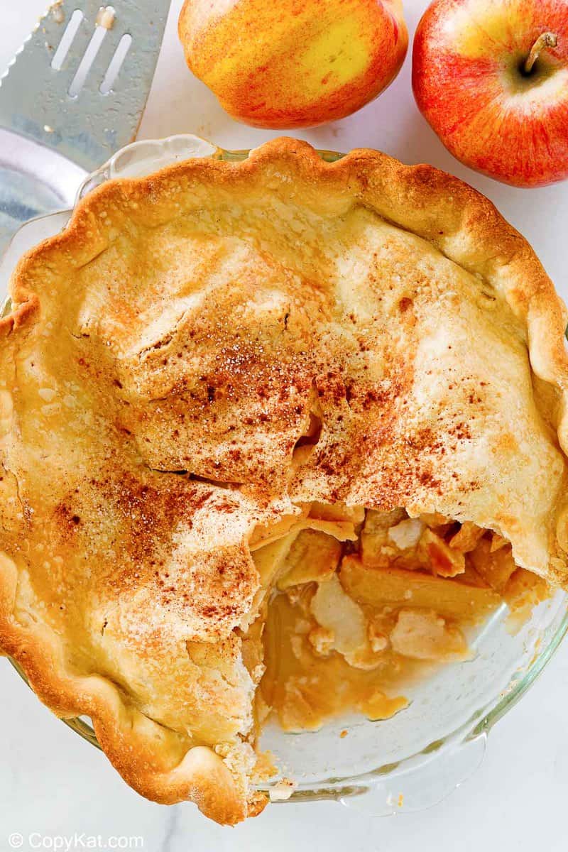 overhead view of an old fashioned apple pie and 2 apples