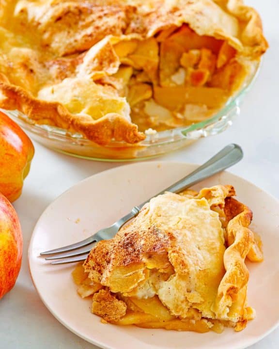 old fashioned apple pie and a slice on a plate