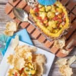 pineapple mango salsa in a pineapple and on tortilla chips