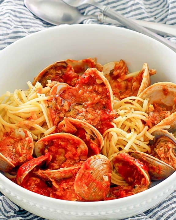 red clam sauce, clams, and pasta in a bowl