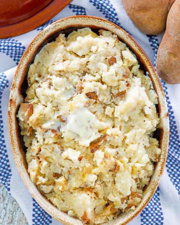 overhead view of roasted garlic mashed potatoes in a serving dish
