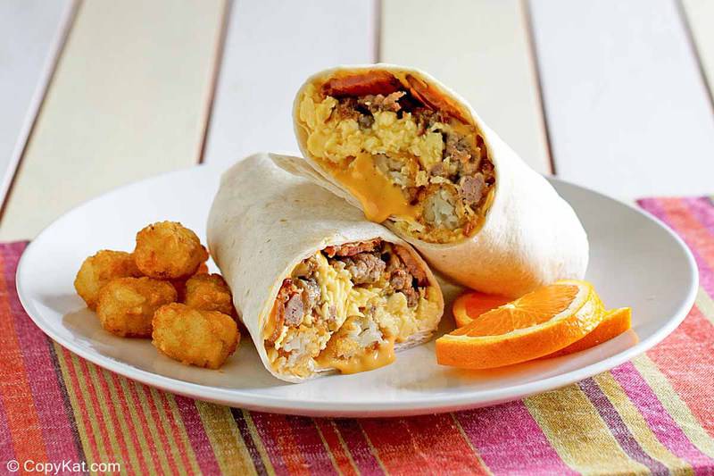 meat and cheese breakfast burrito and tater tots on a plate