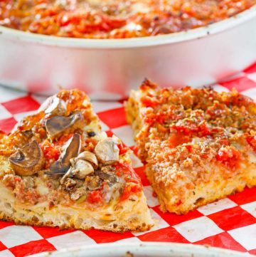homemade deep dish pizza in pans and slices on parchment paper