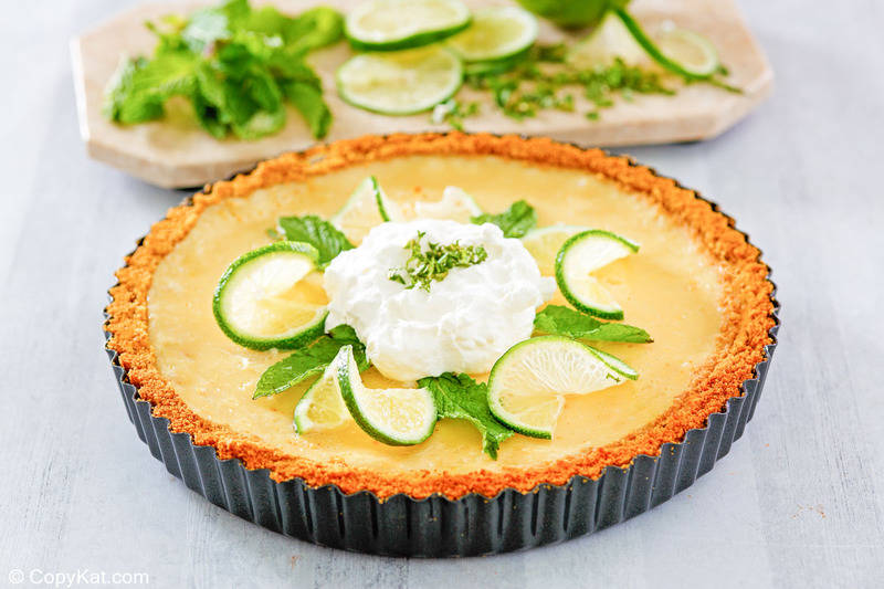 homemade Anthony's key lime pie topped with whipped cream, lime slices, and mint leaves