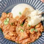butter chicken and rice in a blue bowl