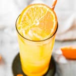 fuzzy navel cocktail garnished with an orange slice