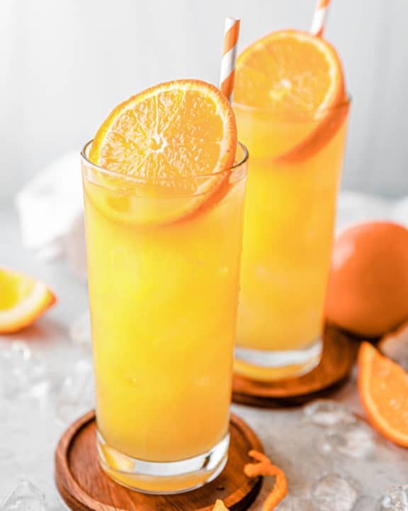 two fuzzy navel drinks on coasters