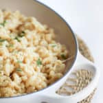 white cheddar mac and cheese in a serving dish on a braided mat