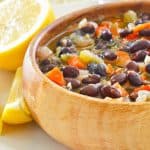 a bowl of black bean soup and a lemon